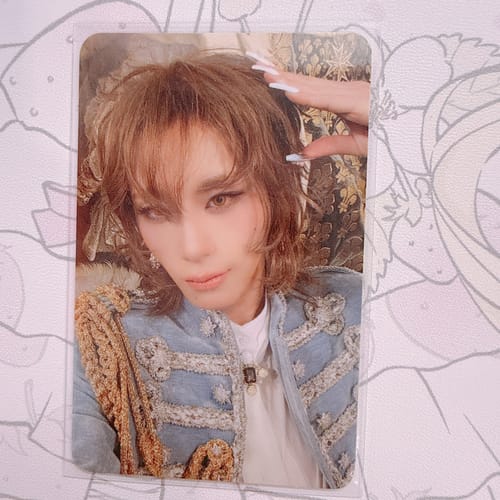Reviewer's XLOV 'I,God' official photocard, displayed in a clear sleeve, showing a person in a detailed blue jacket.