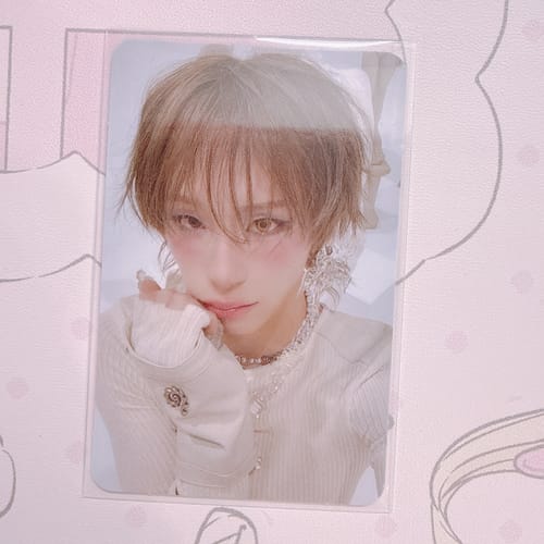 Reviewer's XLOV "I,God" official photocard, showing a person with light hair wearing a white sweater.
