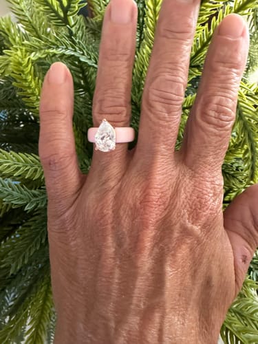 Customer's hand wearing the light pink Silicone Ring with a large pear-cut stone.