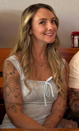 Customer smiling while wearing the gold-toned Starfish Link Necklace.