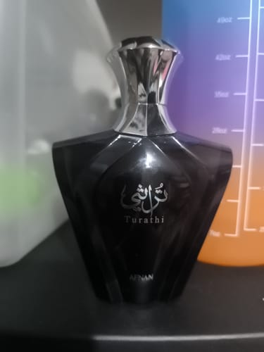 Reseñador muestra el frasco oscuro con tapa plateada del perfume Afnan Turathi Blue.