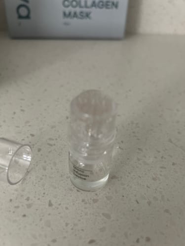 A customer's Micro Infusion System with its cap off, sitting on a speckled bathroom counter.