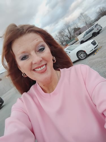 Customer smiling outdoors, showing her facial skin after using The Micro Infusion System.