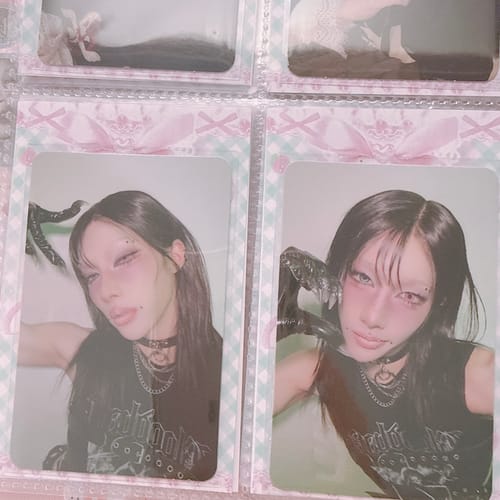 Customer's XLOV 'I,God' official photocards displayed in a clear binder sleeve with a decorative pink border.