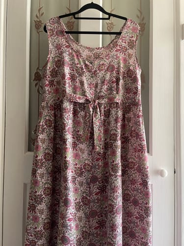 Customer's floral summer dress made from the Printed Cotton Lawn fabric, hanging on a hanger.