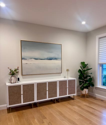 Customer's Misty Morning Canvas Art hanging on a wall above a white and brown sideboard in a dining room.