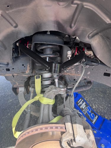 Customer's Upper Control Arm Suspension Kit installed in the wheel well of their Ram 1500 truck.