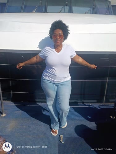 Customer wearing the light blue loose drawstring jeans with a white t-shirt while standing on a boat deck.