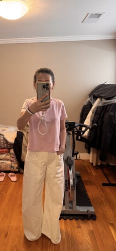 Customer wearing the off-white Wide Leg Cargo Flap Jeans with a pink t-shirt, showing the full-length fit in a room.