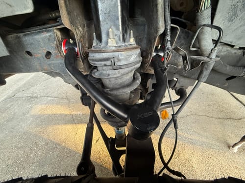 Customer's new black Front Upper Control Arm installed on the front suspension of a truck.