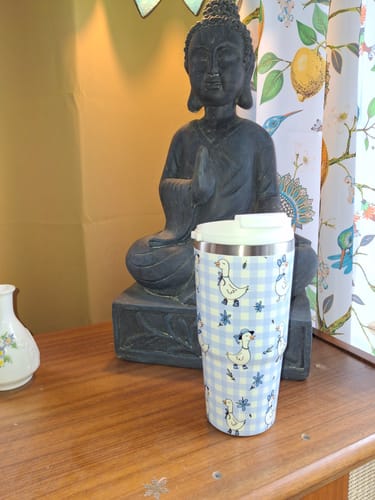 Customer's Little Goose Lane To-Go Buddy with a cute blue gingham and goose pattern, on a wooden table.
