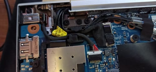 Client montrant le connecteur d'alimentation DC installé à l'intérieur de son ordinateur portable.