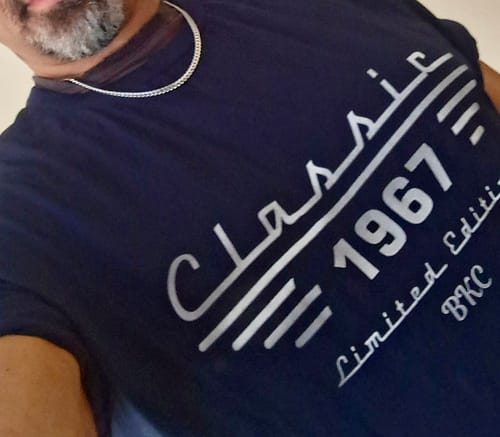 A reviewer wearing a dark blue custom T-shirt with "Classic 1967" printed in a silver stylized font.