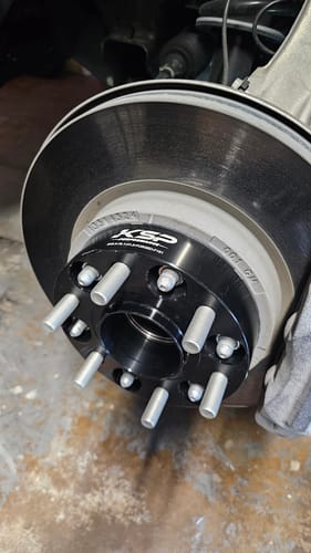 Customer's black 1.5" hubcentric wheel spacer installed on the wheel hub of a Chevy Silverado.