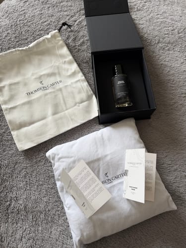 Customer's Rouge Avenue Eau de Parfum displayed with its black box, branded pouch, and complimentary sample cards.