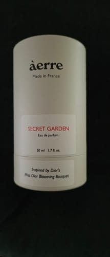 Customer's white cylindrical packaging for their Secret Garden eau de parfum.