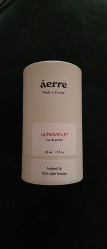 Reviewer showing the white cylindrical packaging for their Àerre Ultraviolet perfume.