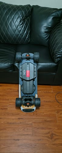 Customer's MEEPO Edge electric skateboard shown upside down on a wood floor, highlighting the large black wheels.