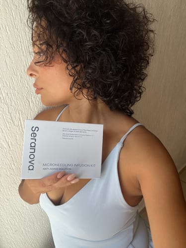 Customer holding the white box for the Seranova Microneedling Infusion System.