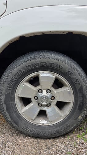 Customer's original factory wheel on a Toyota truck before installing the wheel spacer adapters for an upgrade.