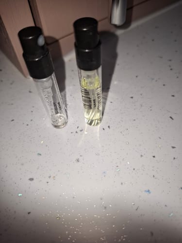 Customer's two 2ml samples of Shelby Lane Eau de Parfum, one empty and one partially full, on a speckled counter.