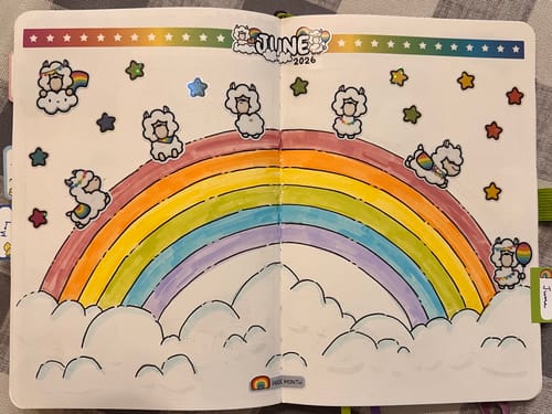 Reviewer's open journal decorated with cute llama stickers and a large rainbow drawing.