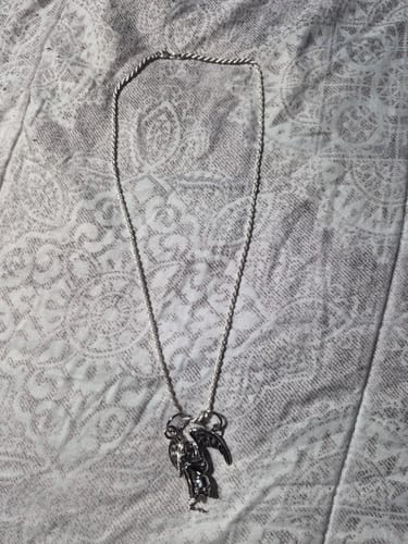 Customer's Weeping Angel Pendant on a silver rope chain, displayed on a patterned surface.