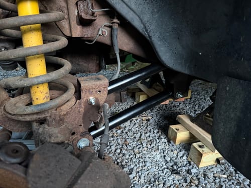 Customer photo of the new black Fixed Length Control Arms installed on the rusty undercarriage of a Dodge Ram.