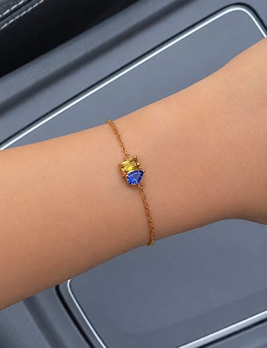 Customer wearing the Forever Duo Birthstone Bracelet on their wrist, showing the yellow and blue heart-shaped stones on a fine chain.