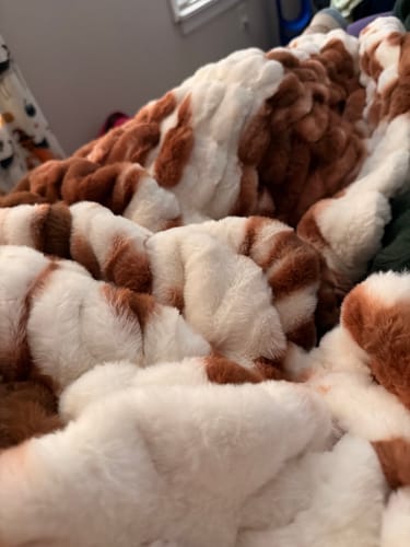 Close-up: Customer's plush Hugs Fannie Blanket showing the soft brown and white cow print texture.