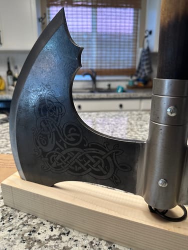 Customer's close-up of the Norse Double-Edged Axe "Jotungard" showing the intricate, dark engraving on the blade.