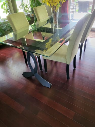 Reviewer's dining table with black 418 Curva curved legs supporting a glass tabletop.