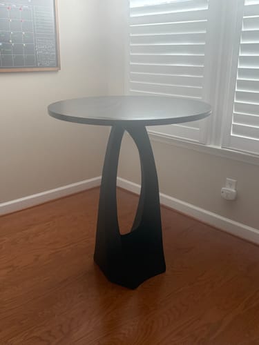 Customer's sleek black 616 Tulipe counter table base with a custom round top in the corner of a room.