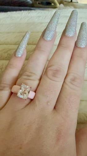 Customer's hand wearing the Silicone Ring with a large emerald-cut CZ and a light pink band.