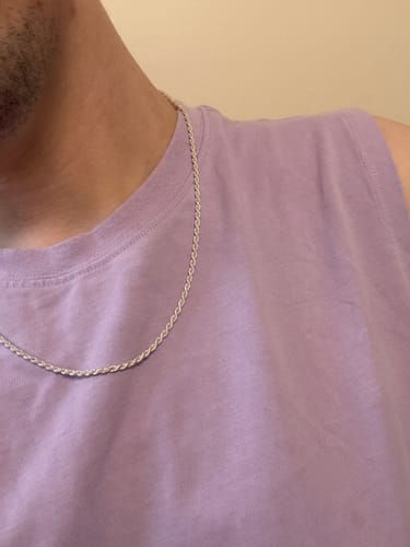 Customer wearing the Sterling Silver Rope Chain against their collarbone with a purple top.