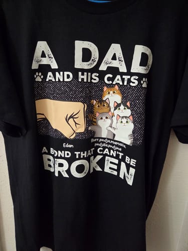 Reviewer's black personalized shirt with the text 'A Dad and His Cats' and a graphic of a fist bumping multiple cats.