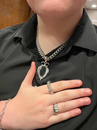 Customer wearing the Mirror Pendant on a 10mm Cuban chain against a black shirt, with their hand on their chest.