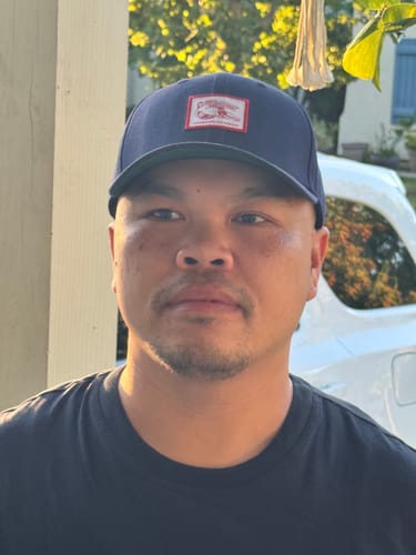 Customer wearing the navy Big Structured Baseball Cap with a front patch, looking forward outdoors.