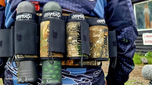 A reviewer wearing the comfortable PRO DNA REFLEX HARNESS in a terrain camo pattern, loaded with pods.