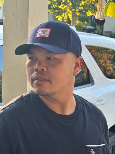 Reviewer wearing the navy Big Structured Baseball Cap, shown from a side angle while looking away.
