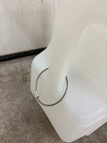 Close-up of a customer's white 5 Gallon Jug with a stainless steel cable loop added to the handle.