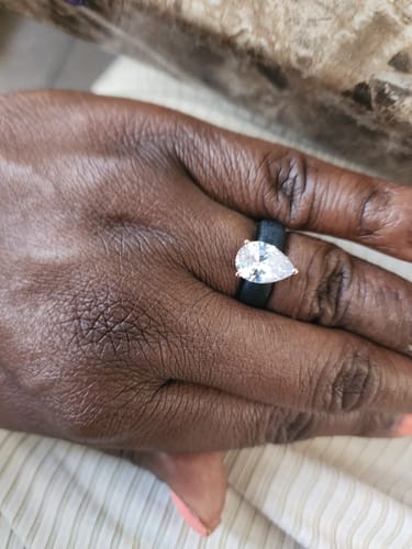 Customer's hand wearing the Women's Silicone Ring with a large, pear-cut cubic zirconia.