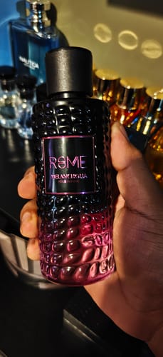 Un cliente sostiene en la mano el perfume Rome Melancholia, mostrando su botella texturizada en degradado negro y rosa.