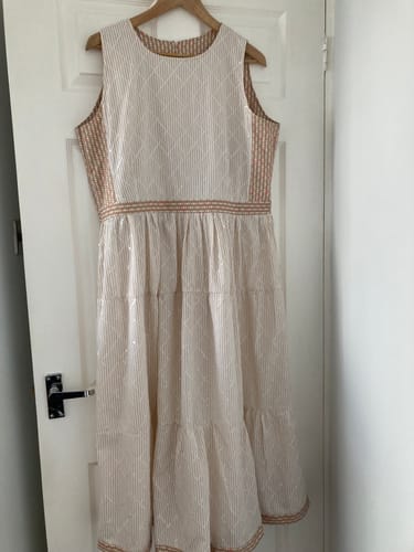 Reviewer's homemade dress using the printed sequin poly-cotton fabric, hanging on a hanger.