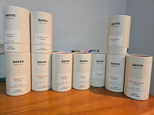 Customer's collection of àerre perfume packages on a wooden table, including two boxes of Odyssey #5.