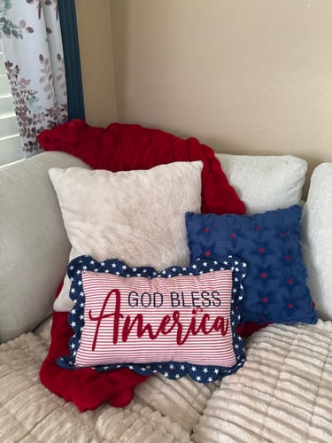 Customer's red Patriotic Bandana Blanket draped on a couch with several patriotic pillows.