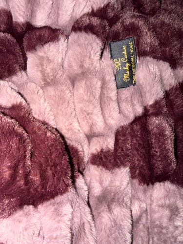 Close-up from a reviewer of the soft, plush Hugs Shelby Mulberry Diamond Blanket, showing its texture and brand tag.