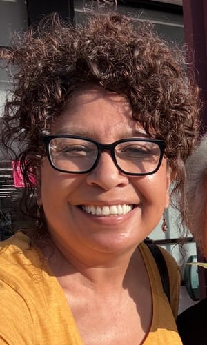 A close-up of a smiling reviewer showing her skin after using The Micro Infusion System for wrinkles.