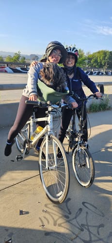 Customer and a friend posing with a dog in the green Kvisp Dog Bike Carrier on a bike.