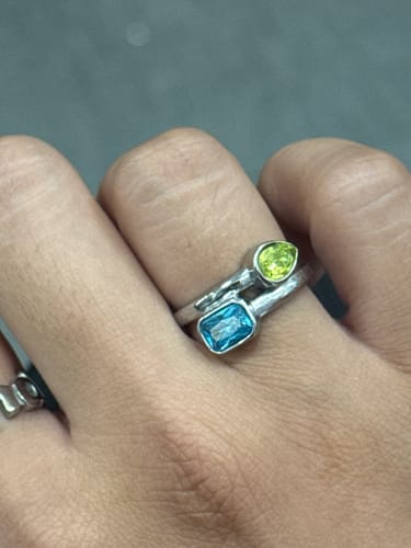 Customer wearing the Blair Birthstone Ring in silver, showing the light green and light blue stones.